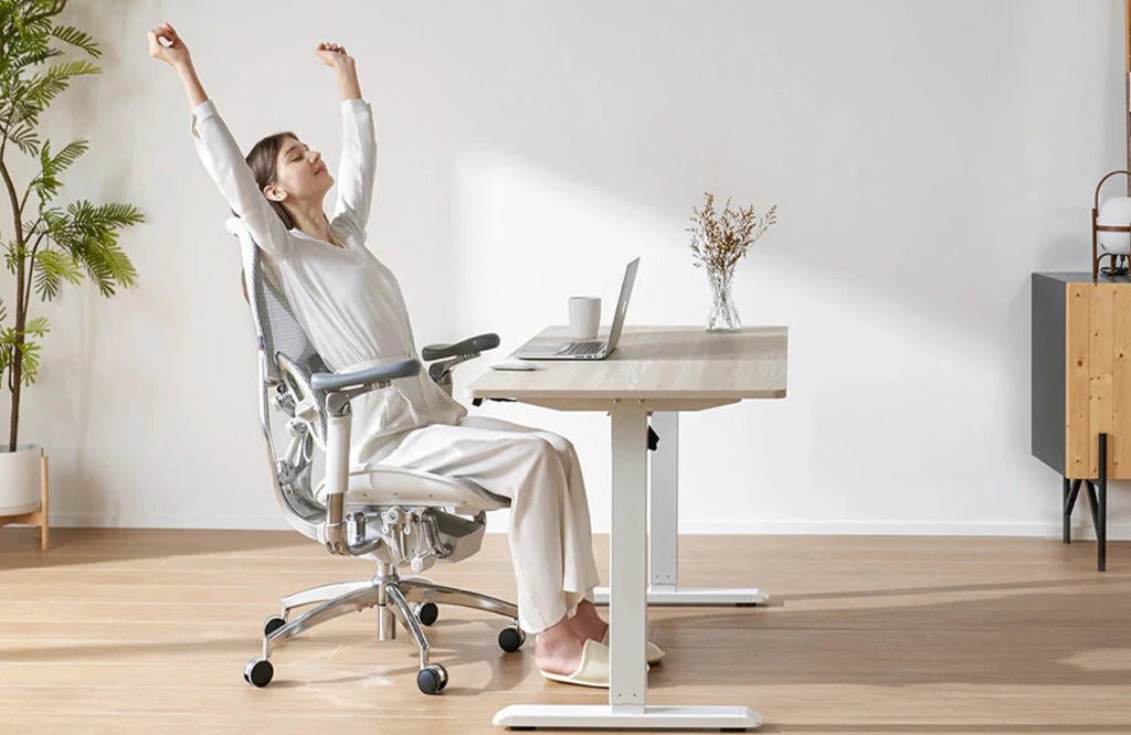 Eine Person sitzt am Schreibtisch in einem neuen ergonomischen Stuhl und gewöhnt sich an die aufrechte, gesunde Sitzhaltung.